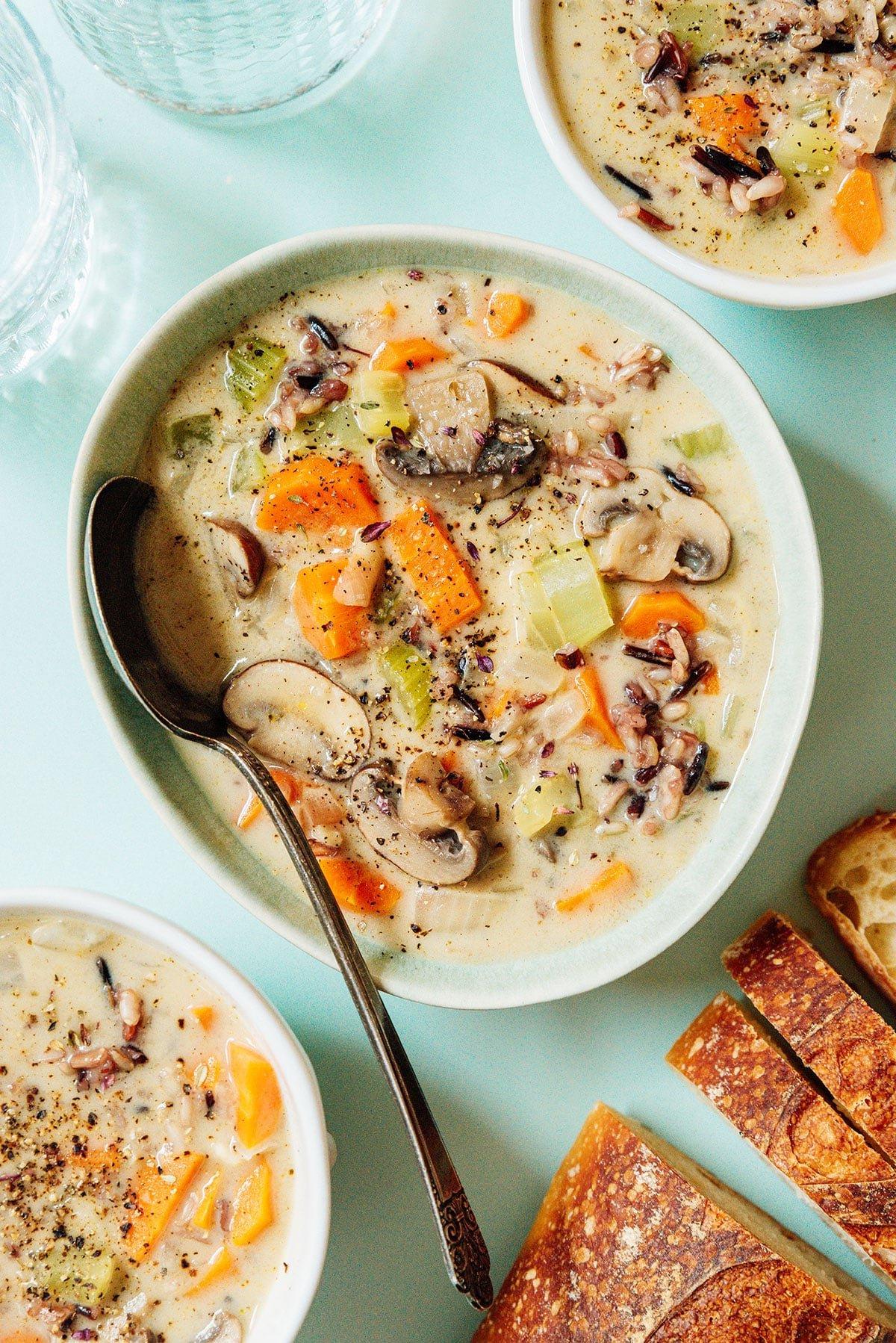 Eine Schüssel Wildreissuppe mit einem Löffel.
