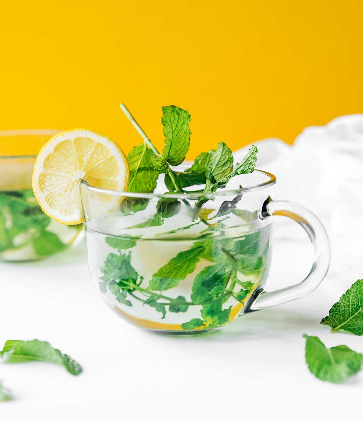 Zubereitung von frischem Minztee 2 Frischer Minztee in einem klaren Glas mit einer Zitronenscheibe