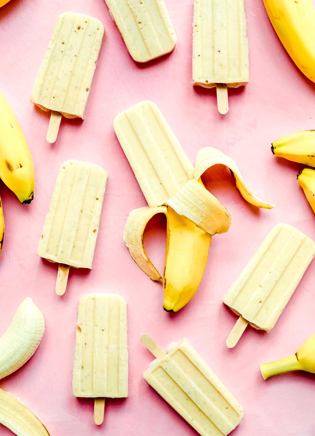 Viele Bananen-Popsicles auf einem pinkfarbenen Hintergrund.