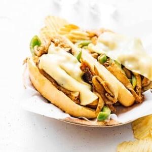 Vegetarisches Philly Cheesesteak mit zerzupften Pilzen 11 Vegetarisches Philly Cheesesteak auf einem Holzbrett.