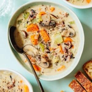 Eine Schüssel Wildreissuppe mit einem Löffel.