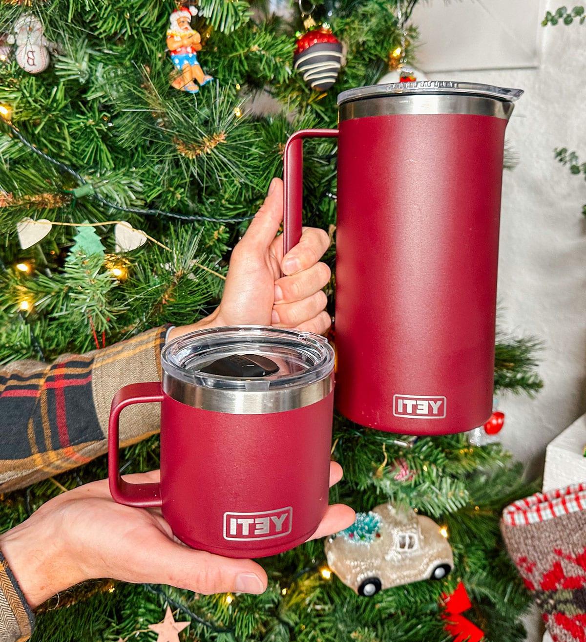 47 Geschenkideen für Feinschmecker 19 Ein Yeti Rambler Krug mit Bechern als Geschenk vor einem Weihnachtsbaum.