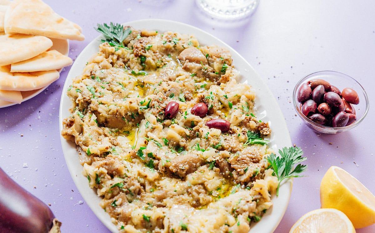 Griechischer Auberginen-Dip (Melitzanosalata) 3 Weiße ovale Platte mit Melitzanosalata.