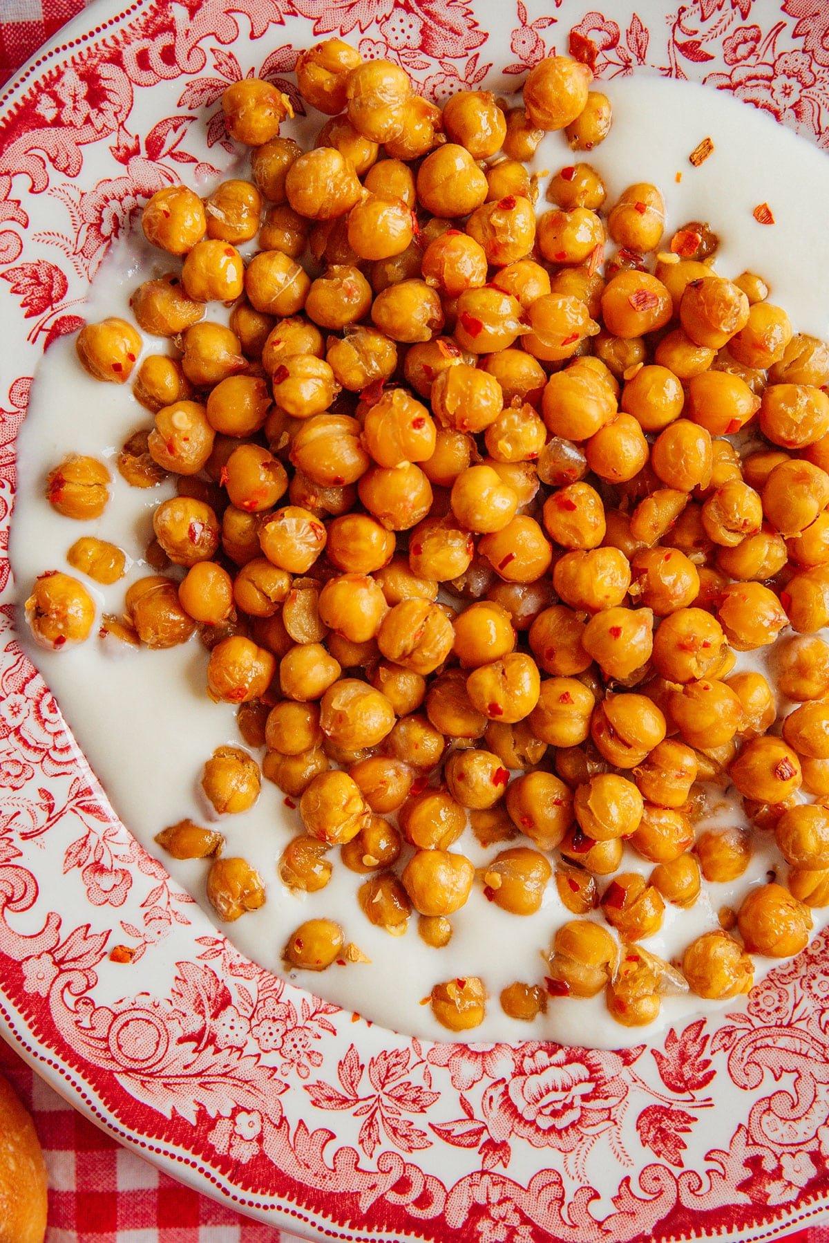 Hot Honey Kichererbsen mit cremigem Feta-Dip auf einer Platte.
