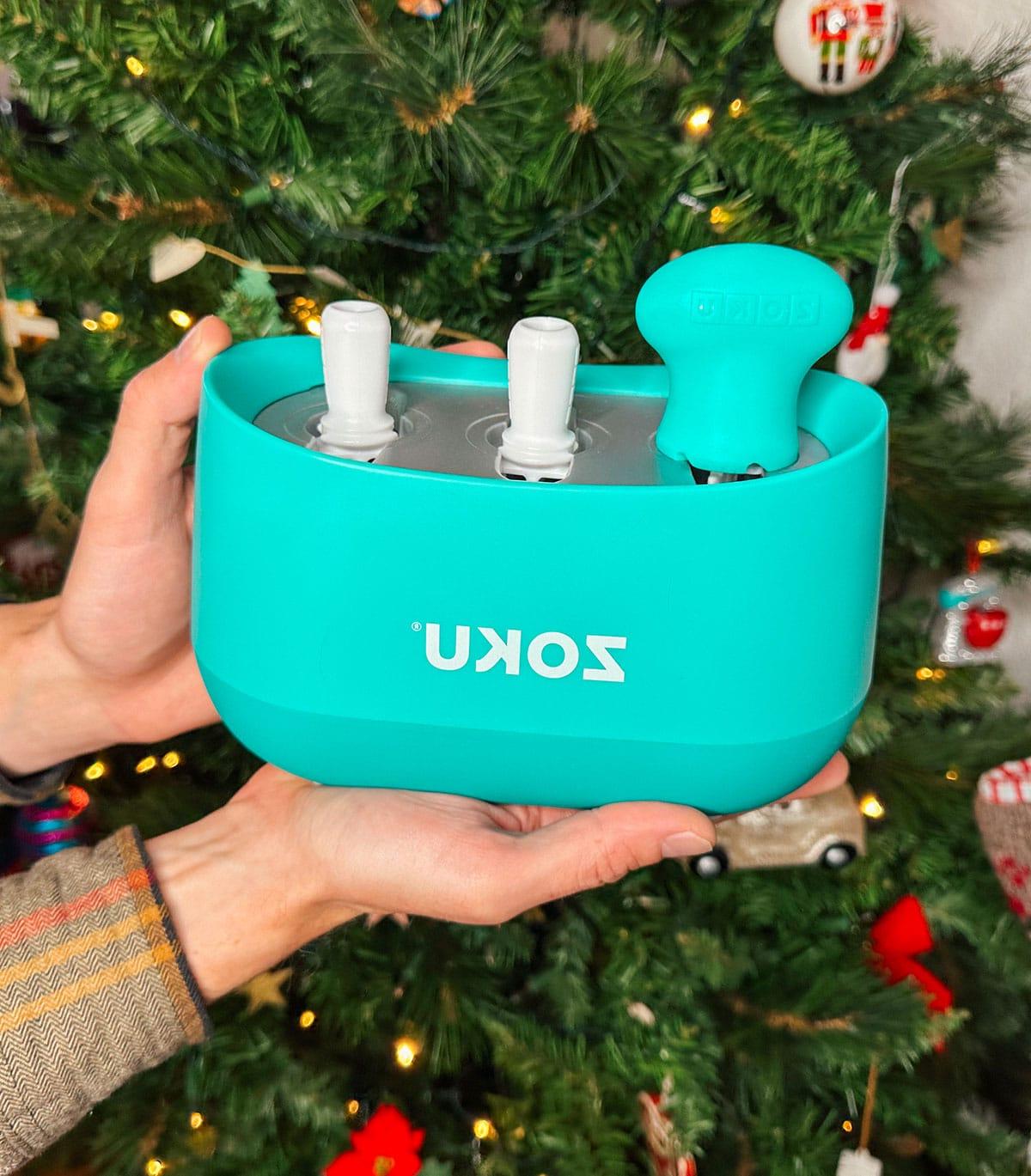 47 Geschenkideen für Feinschmecker 21 Eine Zoku Eis am Stiel Form als Geschenk vor einem Weihnachtsbaum.