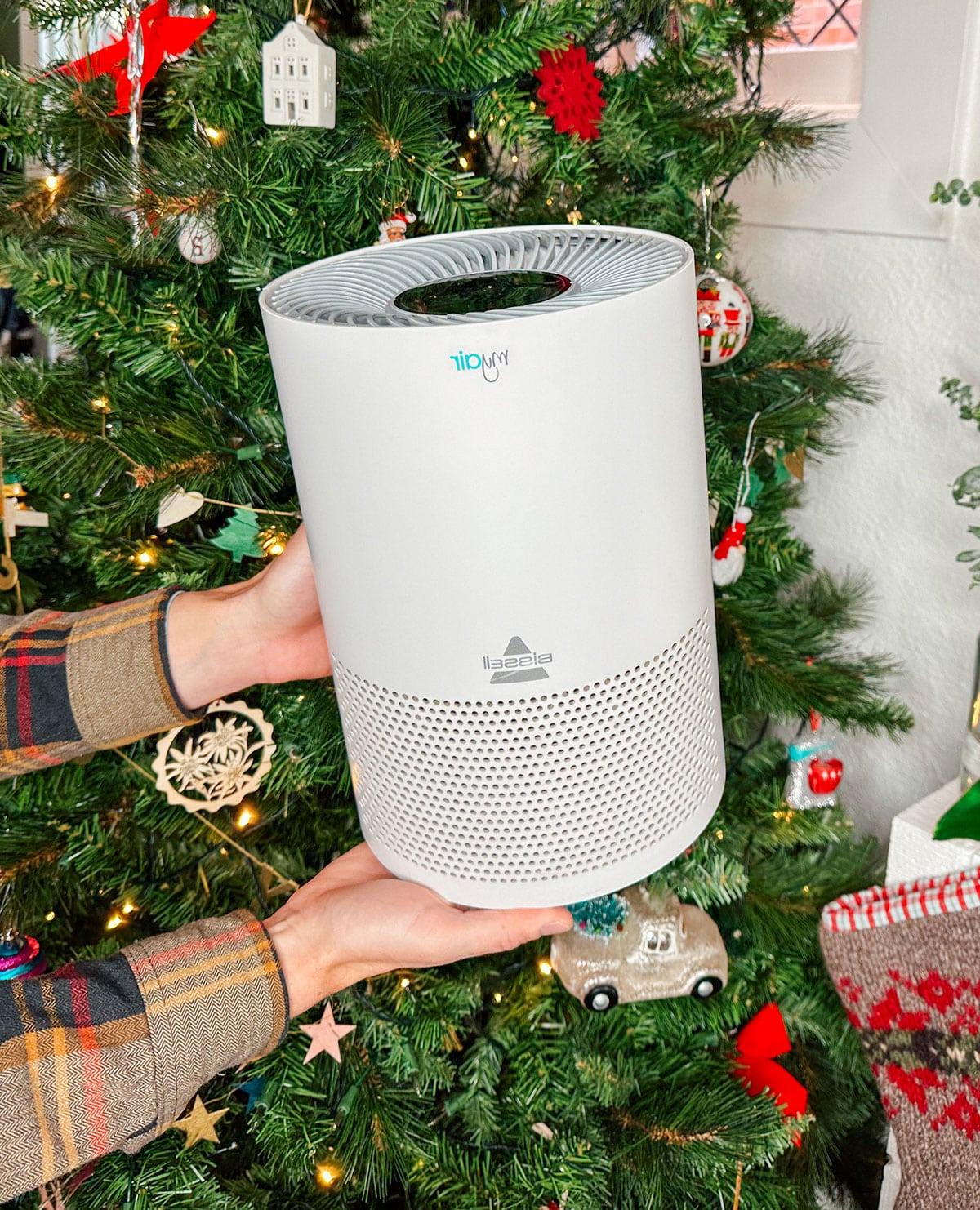 47 Geschenkideen für Feinschmecker 31 Ein Luftreiniger von Bissel oder Levoit als Geschenk vor einem Weihnachtsbaum.