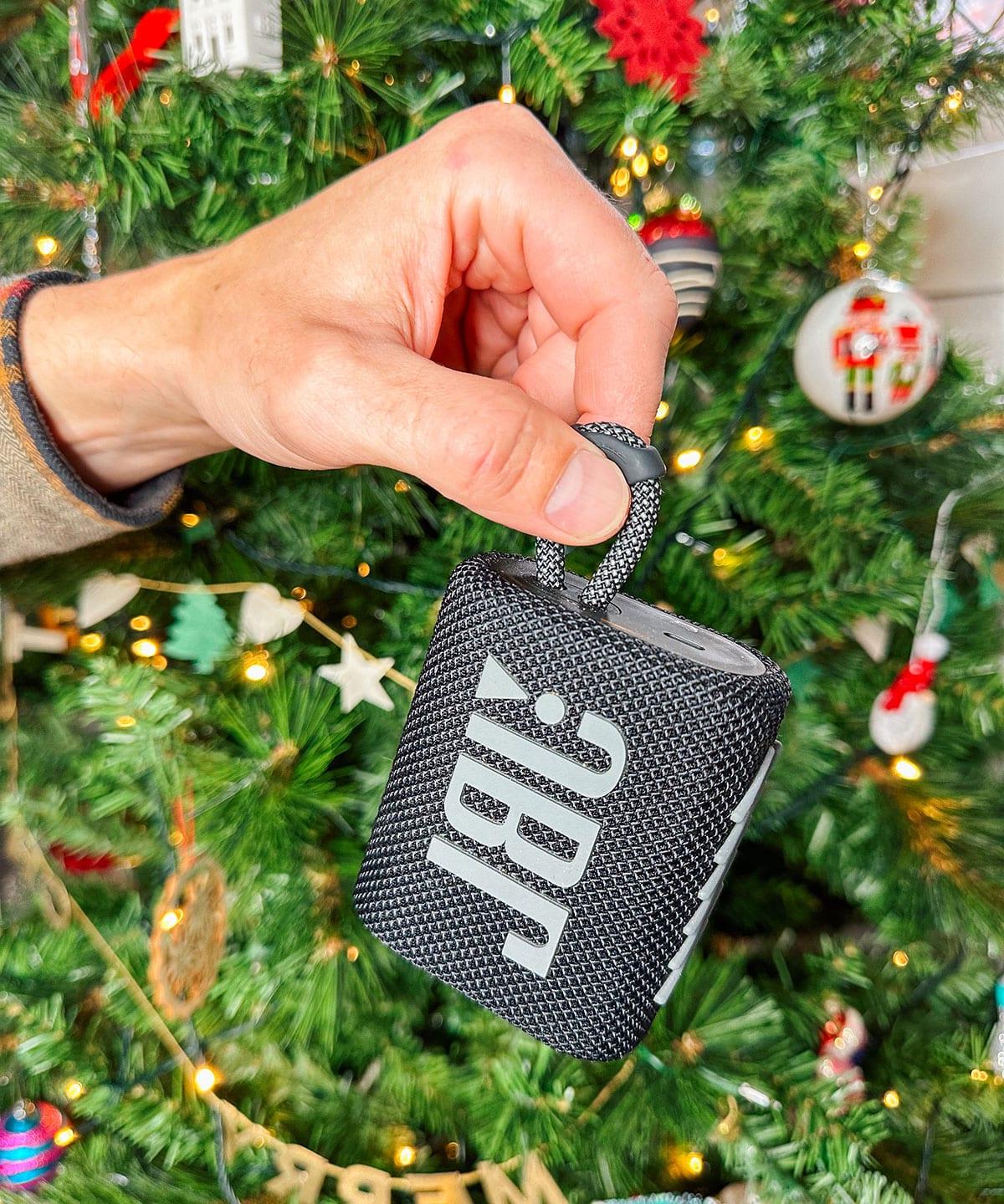 47 Geschenkideen für Feinschmecker 34 Ein JBL Mini Lautsprecher als Geschenk vor einem Weihnachtsbaum.