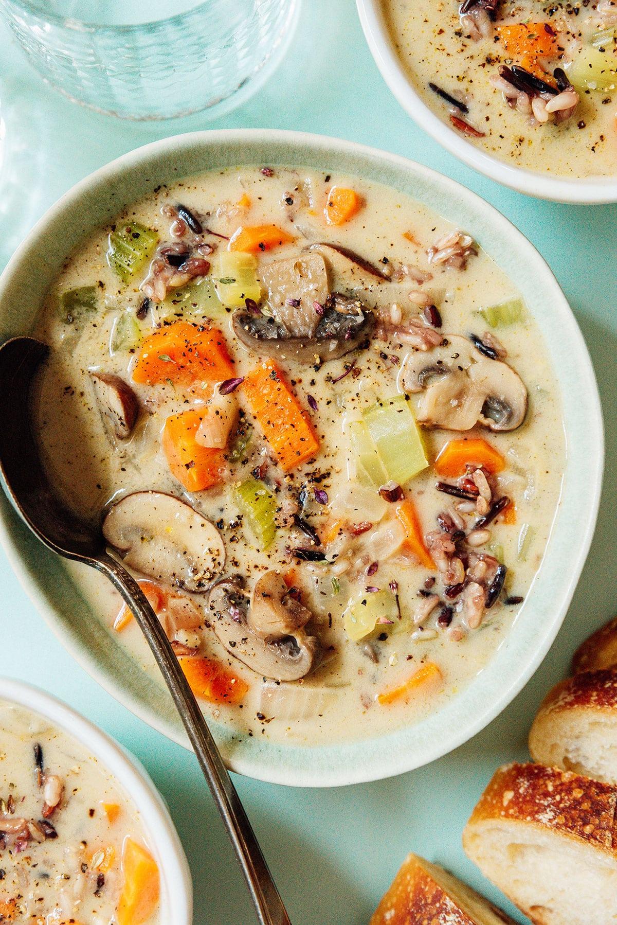 Eine Schüssel Wildreissuppe mit einem Löffel.