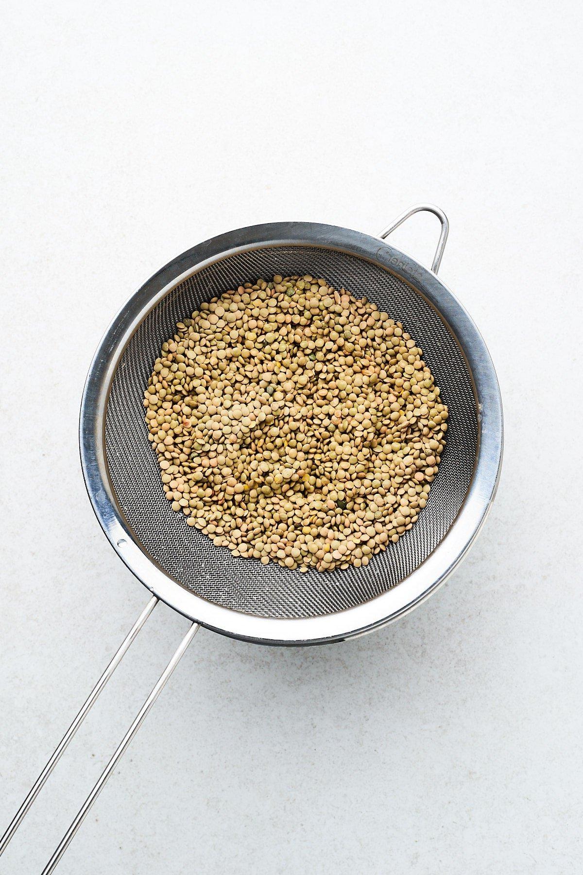 Gespülte Linsen in einem feinen Sieb – bereit zum Kochen.