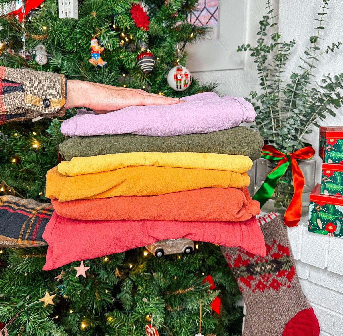 47 Geschenkideen für Feinschmecker 42 Bunte Overalls als stylisches Geschenk vor einem Weihnachtsbaum.