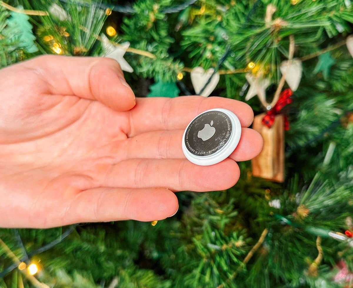 47 Geschenkideen für Feinschmecker 43 Ein Apple AirTag als Geschenk vor einem Weihnachtsbaum.