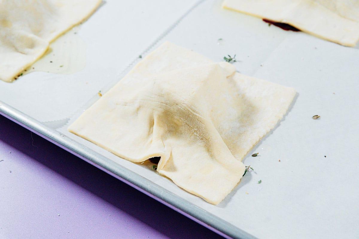 Eine Zwiebeltarte auf einem Backblech zubereiten.