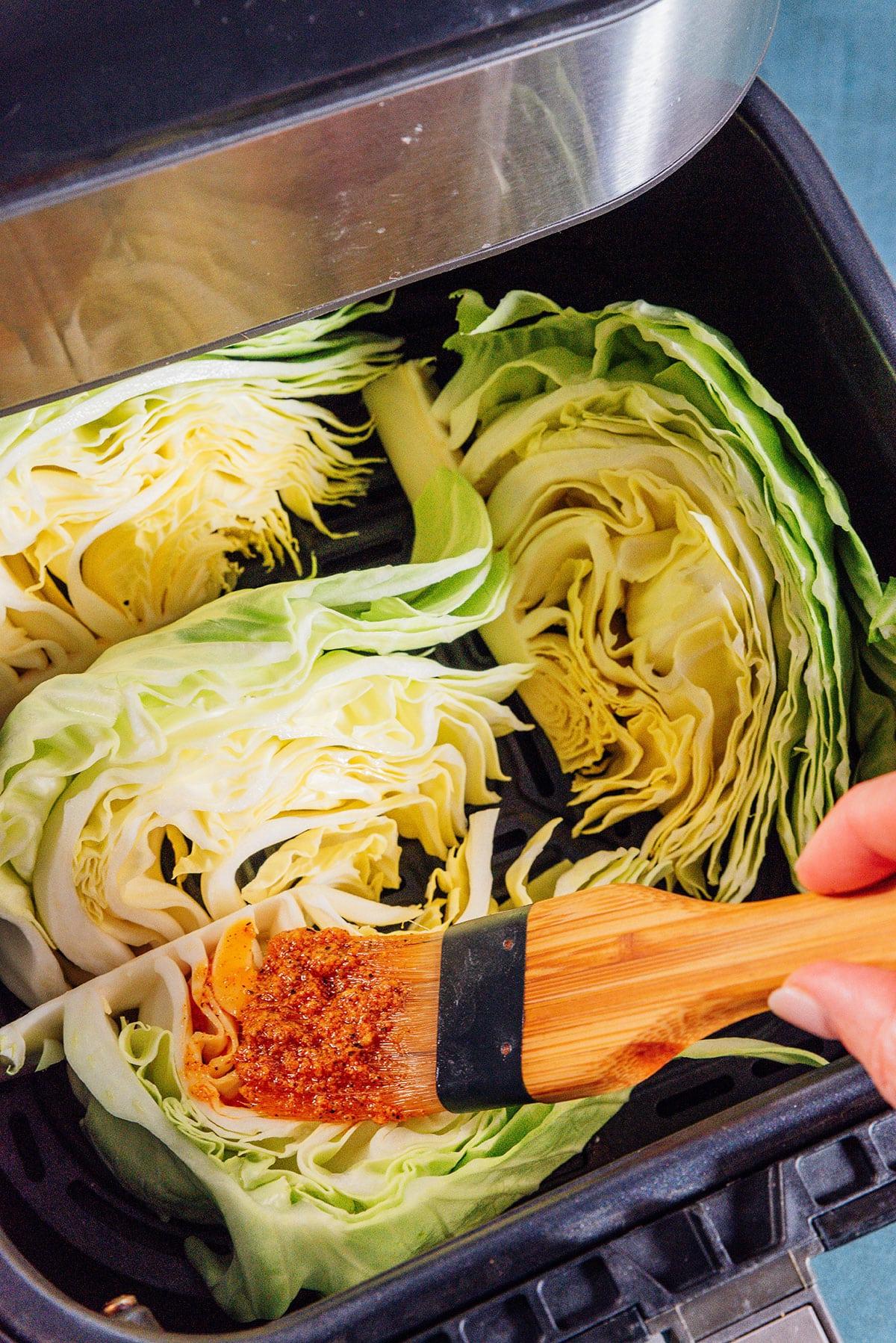 Marinade wird mit einem Pinsel auf Kohlspalten in einer Heißluftfritteuse aufgetragen.