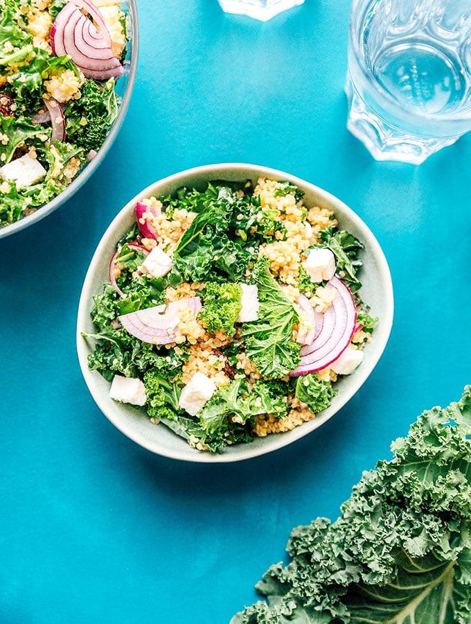 Quinoa-Grünkohl-Salat in einer Schüssel auf blauem Hintergrund
