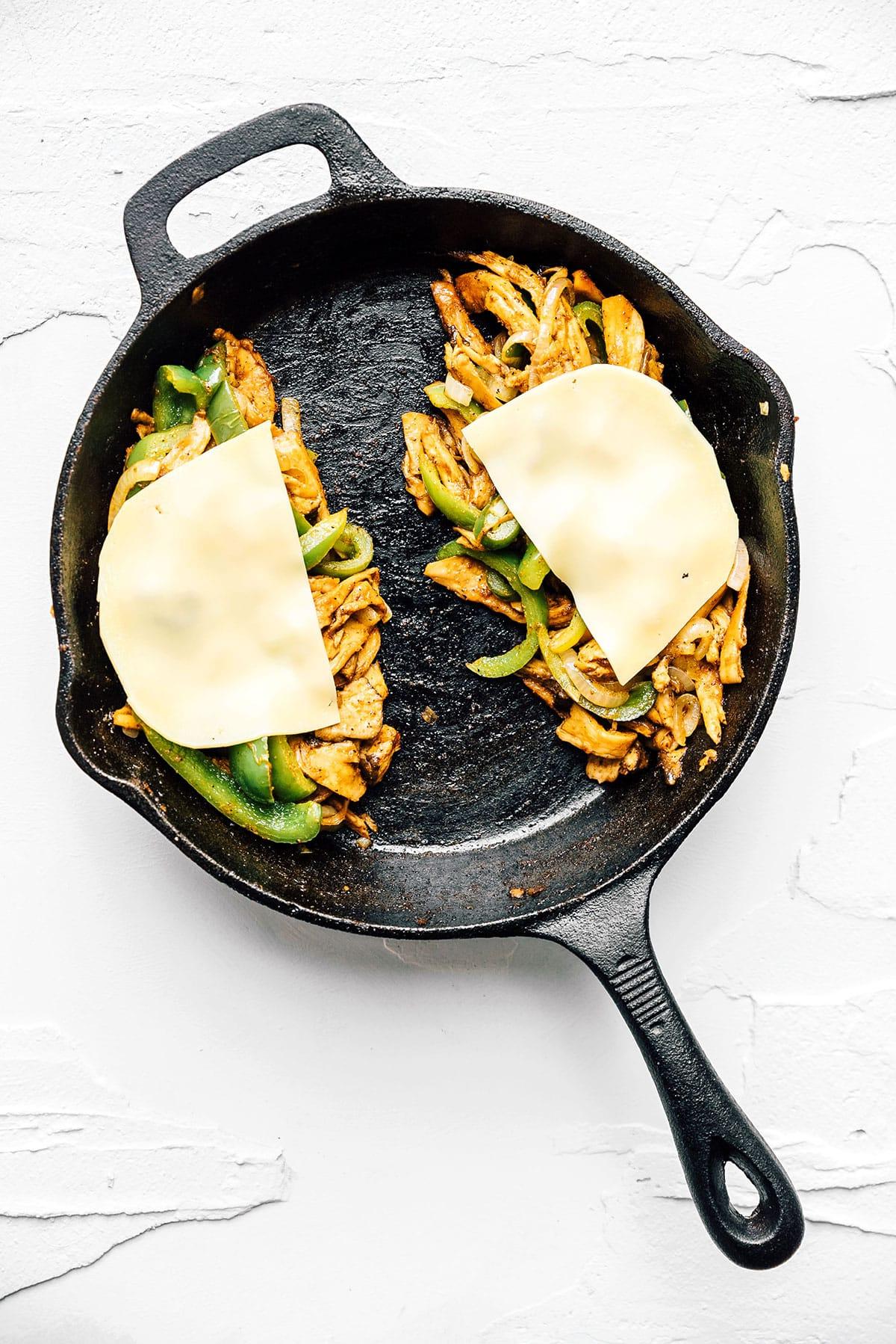 Vegetarisches Philly Cheesesteak mit zerzupften Pilzen 8 Vegetarisches Cheesesteak wird in einer gusseisernen Pfanne fertiggestellt.