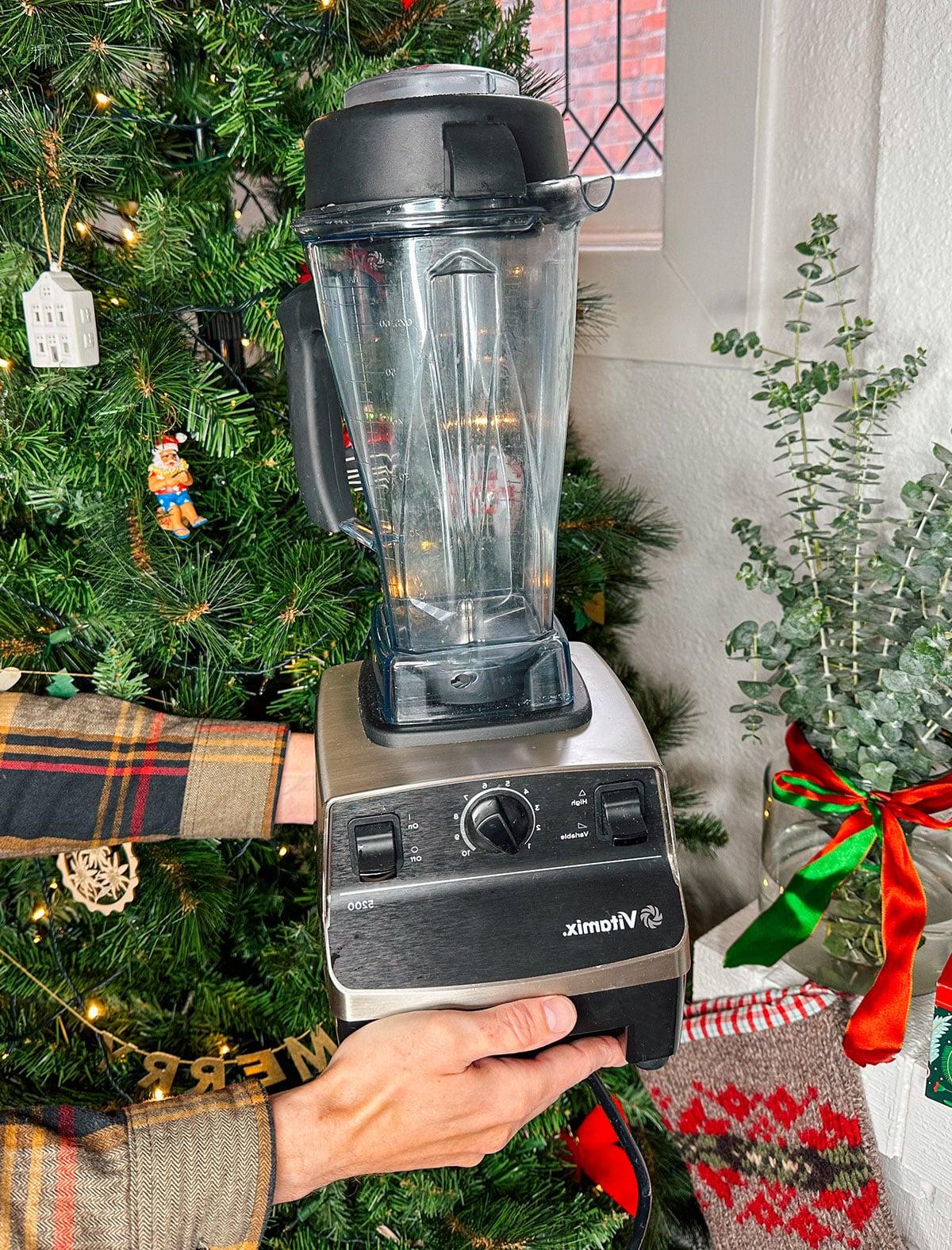 47 Geschenkideen für Feinschmecker 9 Ein Vitamix Hochleistungsmixer als Geschenk vor einem Weihnachtsbaum.