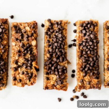 Photo of several nut-free granola bars topped with loads of chocolate chips lined up on a white background