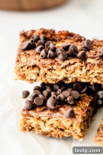 Six homemade nut-free granola bars arranged on a white background, topped with chocolate chips.