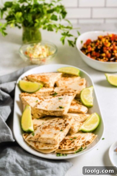 A vibrant platter of freshly cooked cream cheese quesadillas, cut into triangles, ready to be served as a family meal.