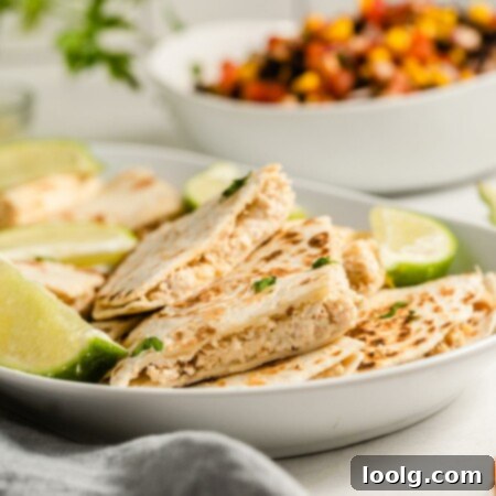Close-up of a stack of creamy chicken and cream cheese quesadillas, with a perfect golden-brown crust.