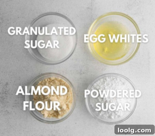 Ingredients for macaron shells laid out: egg whites, granulated sugar, powdered sugar, almond flour, and orange food coloring.