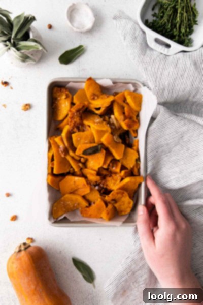 Butternut squash being cut into half-moons on a cutting board