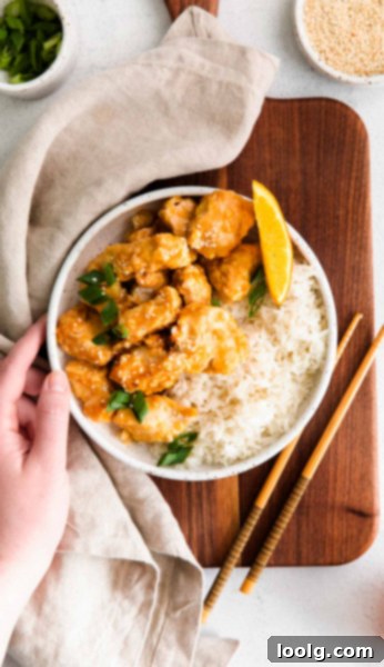Air fryer orange chicken on a plate with chopsticks