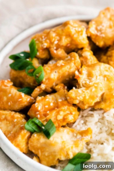 Air Fryer Orange Chicken served with rice and greens