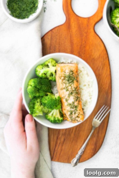 Hand reaching for a plate of cooked air fryer salmon ready to eat