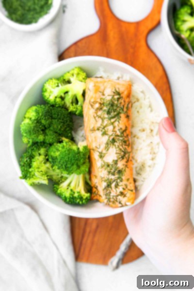 Bowl with a filet of air fryer salmon, broccoli, and rice