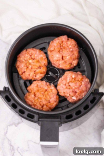 sausage patties cooking in the basket of an air fryer