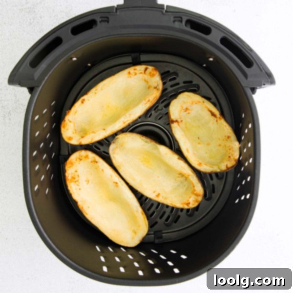 A serving platter with multiple Air Fryer Potato Skins, garnished with fresh chives.