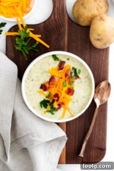 A top-down view of a serving of Instant Pot Colcannon Potato Soup, richly textured and garnished with herbs.