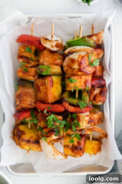 Several cooked chicken pineapple kabobs arranged neatly on a serving dish, ready to be enjoyed.