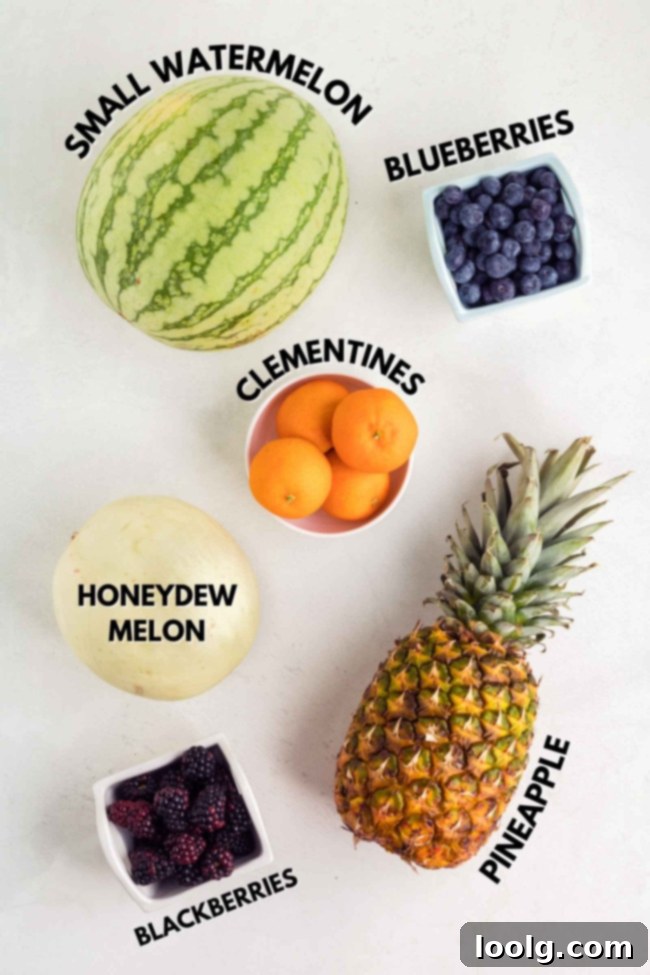 A flat lay photograph showcasing an assortment of fresh fruits, including a whole watermelon, a cut honeydew melon, a pineapple, a bowl of peeled clementines, blueberries, and blackberries, all laid out on a light background, ready for making a vibrant Halloween fruit salad.