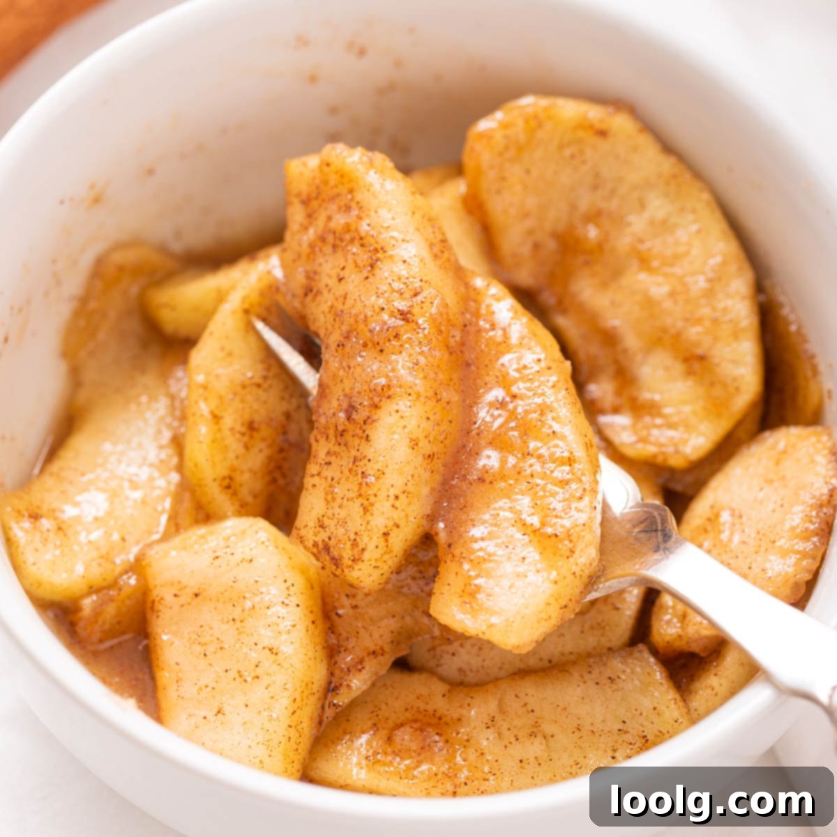 Air fryer apples in a bowl with cinnamon