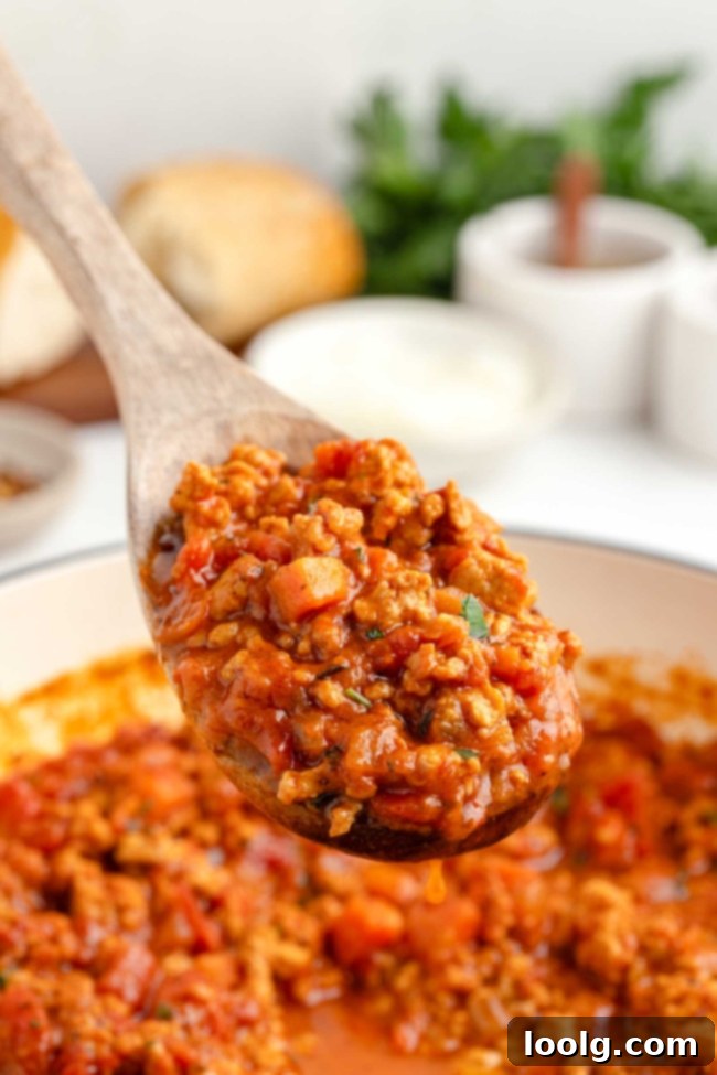A glass container filled with chicken bolognese, ready for storage.