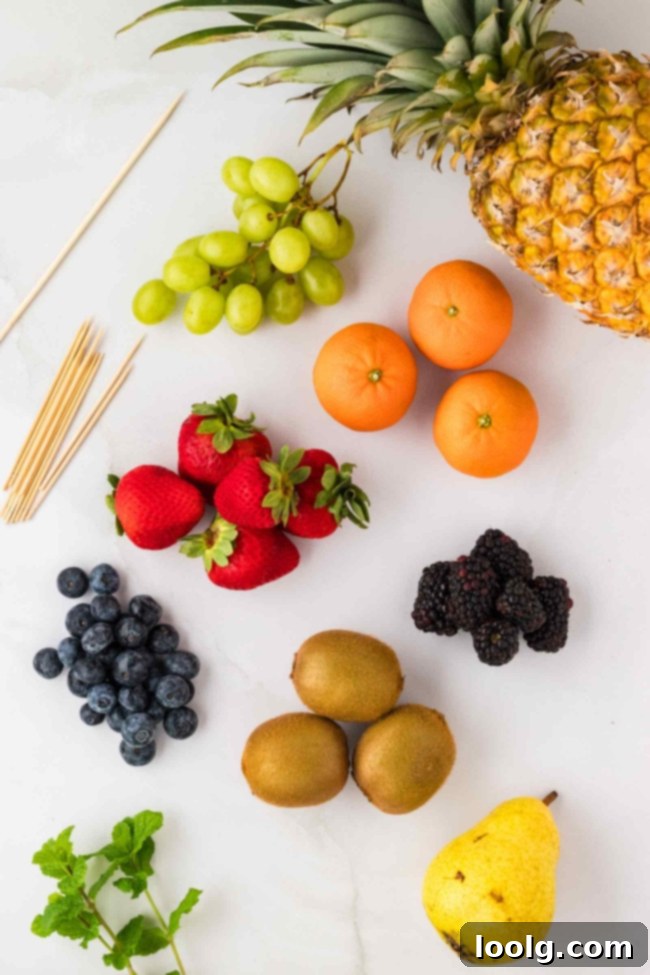 A close-up shot of the fruit Christmas tree, showcasing the arrangement of various fruits like strawberries, kiwi stars, grapes, and blueberries on the pineapple and pear base.