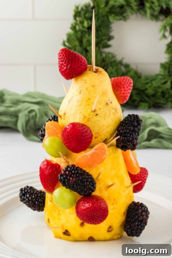 Another perspective of the fruit Christmas tree, highlighting the freshness of the fruits and the meticulous arrangement. A Christmas wreath is visible in the background.