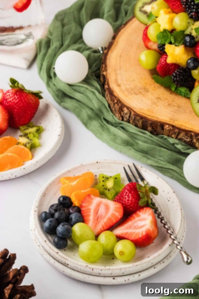 The fruit Christmas tree displayed on a white platter against a festive background, ready for serving.