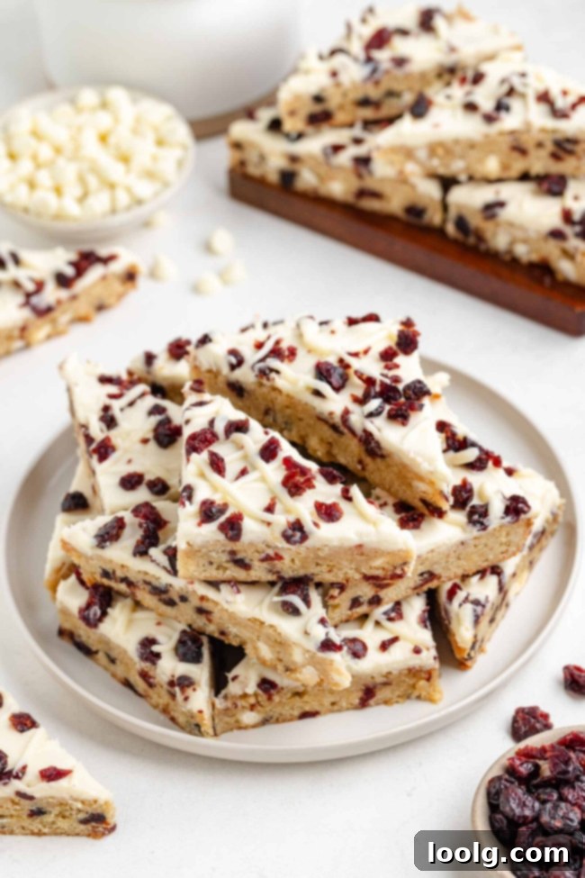 Stacked bliss bars showing the layers of blondie, frosting, and cranberries.