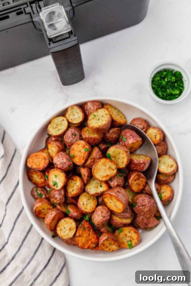 A stack of three air fryer red potato slices on a cutting board, showcasing their crispy texture.