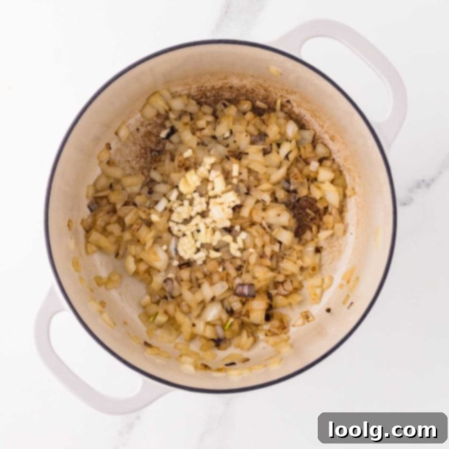 onion and garlic cooking in white dutch oven