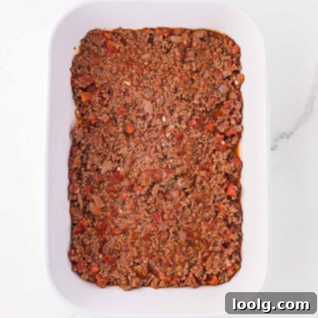 a little sauce covering the bottom of a white casserole dish