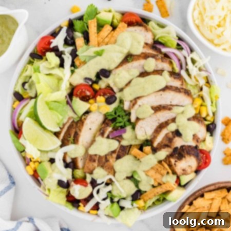 mixed up southwest chicken salad in white bowl with avocado dressing on top