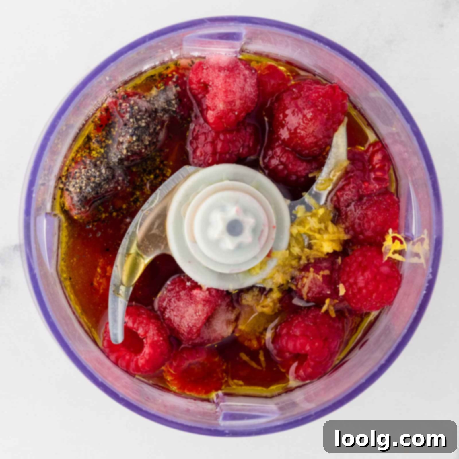 all ingredients needed for raspberry vinaigrette in a food processor