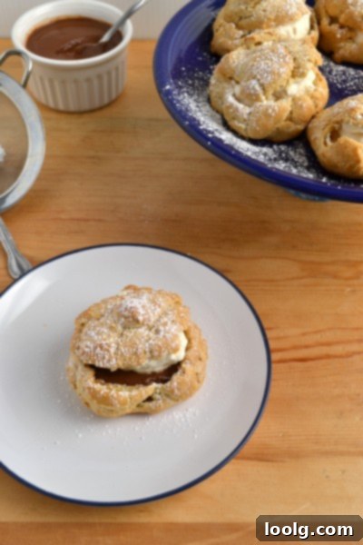 Two whole wheat cream puffs presented on a white serving dish
