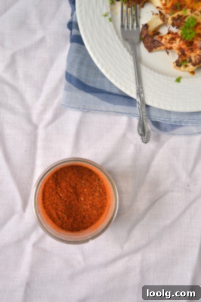 A glass jar filled with freshly made homemade Cajun seasoning, ready for use.