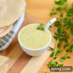 Greek Salad Dressing in a glass jar with fresh herbs