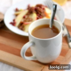 A steaming mug of Instant Hot Apple Cider, garnished with a cinnamon stick.